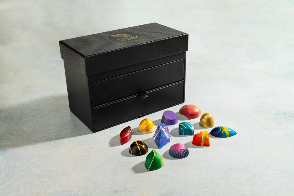 Black jewelry box with colorful gemstone-shaped chocolates 