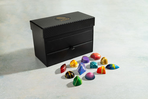 Black jewelry box with colorful gemstone-shaped chocolates 