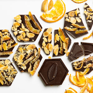 Citrus Almond Mendiants featuring handcrafted artisan chocolate discs topped with roasted almonds and citrus flavors.