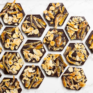 Open Citrus Almond Mendiants displaying handcrafted gourmet chocolate discs.