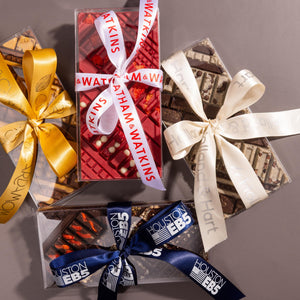 Gift boxes with custom decorative ribbons on a gray background