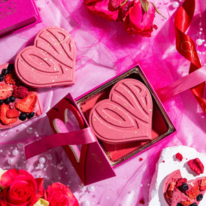 A heart-shaped pink chocolate bar with 'Love' written on it