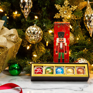 Open Petite Nutcracker 5-piece gift box displaying handcrafted gourmet chocolates.