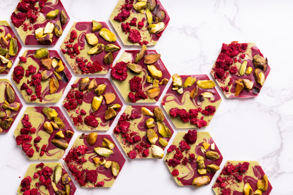 Raspberry Pistachio artisan chocolate mendiants topped with freeze-dried raspberries and roasted pistachios.